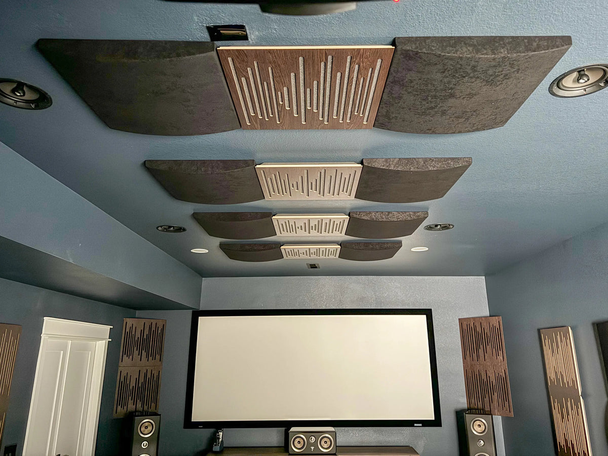 Home cinema ceiling cloud with Wavewood Ultra Lite wood diffusion panels and Cinema Round Premium absorbers above the projection screen and tower speakers.